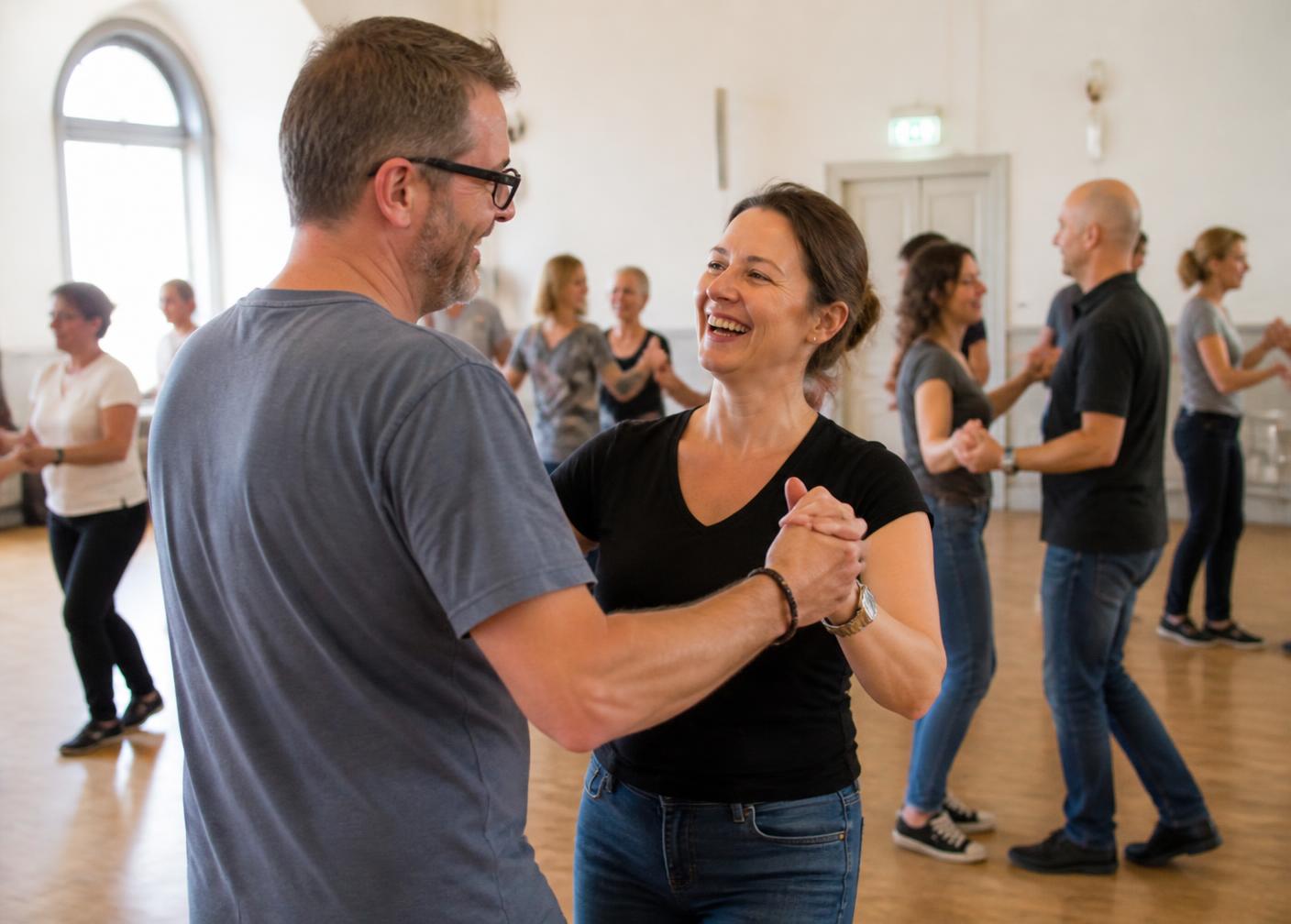 Two beginners laughing while learning a basic dance step