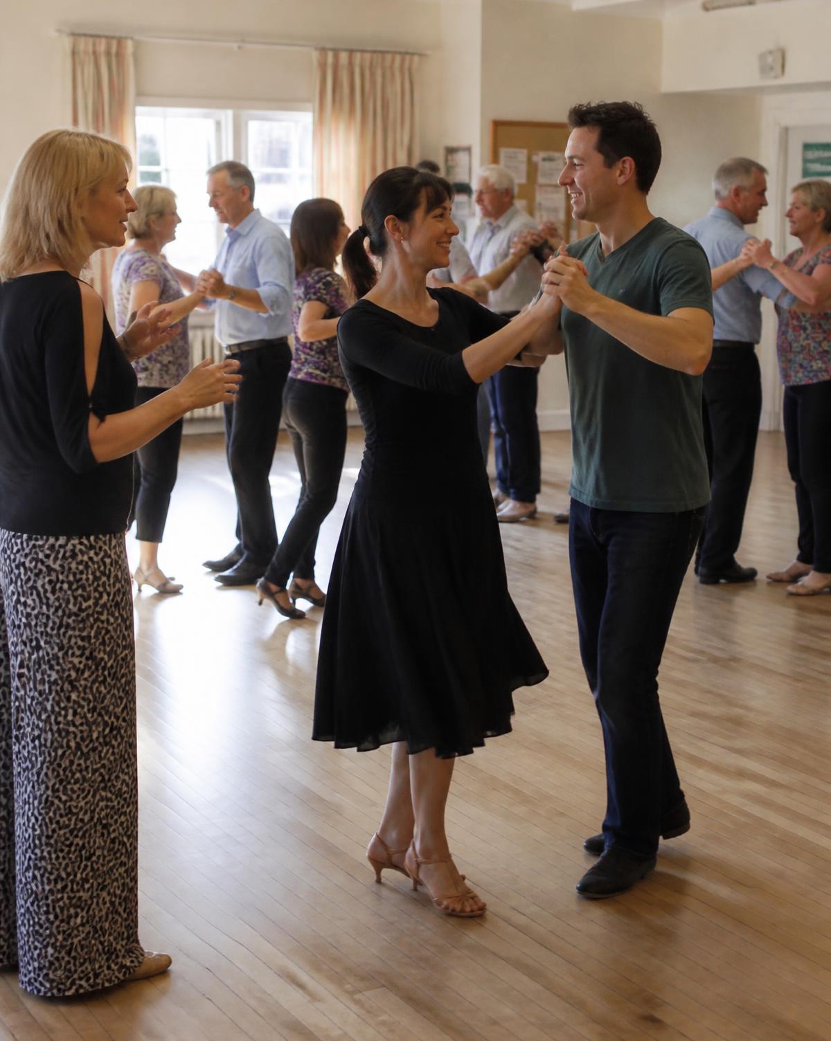 Adults learning a ballroom step together in a bright hall in Cork